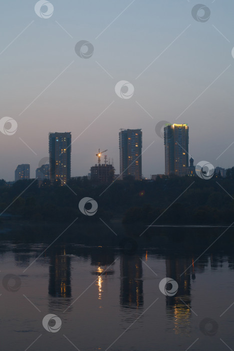 Скачать три здания вечером отражаются в воде фотосток Ozero