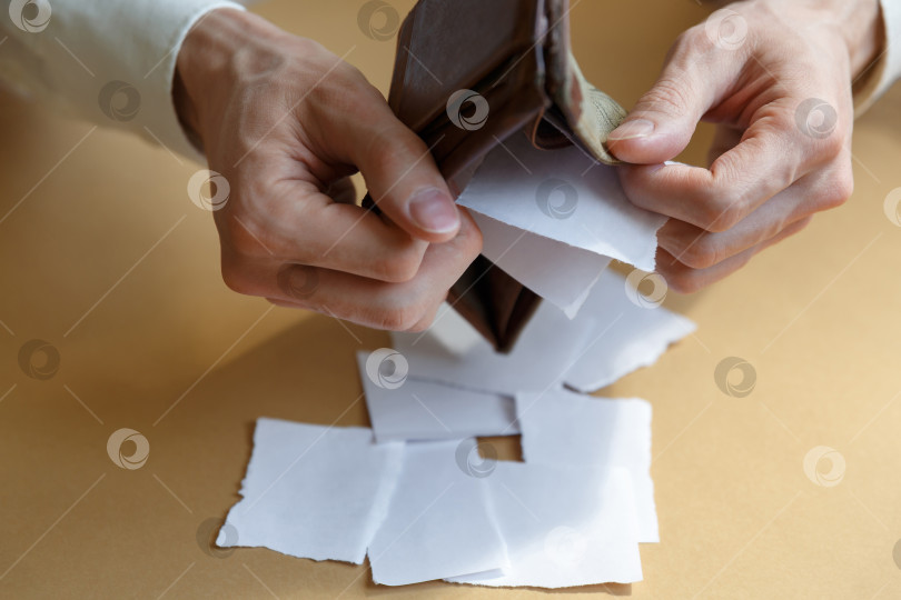Скачать Мужчина вытряхивает бумагу из бумажника на простом фоне фотосток Ozero