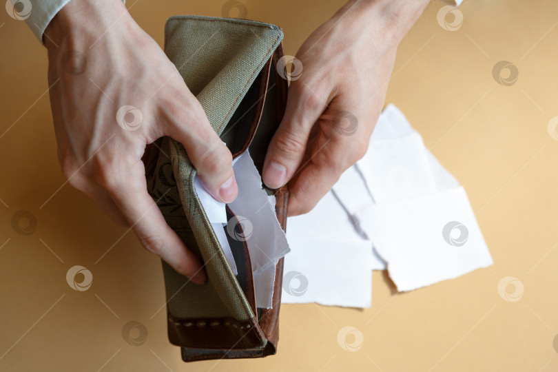 Скачать Пустой бумажник с бумагой в руках мужчины на простом фоне фотосток Ozero