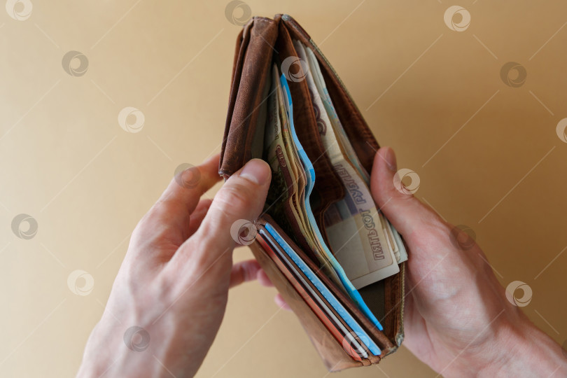 Скачать Кошелек с деньгами в руках мужчины на светлом фоне фотосток Ozero