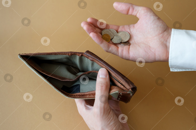 Скачать Пустой бумажник в руках мужчины на простом фоне фотосток Ozero