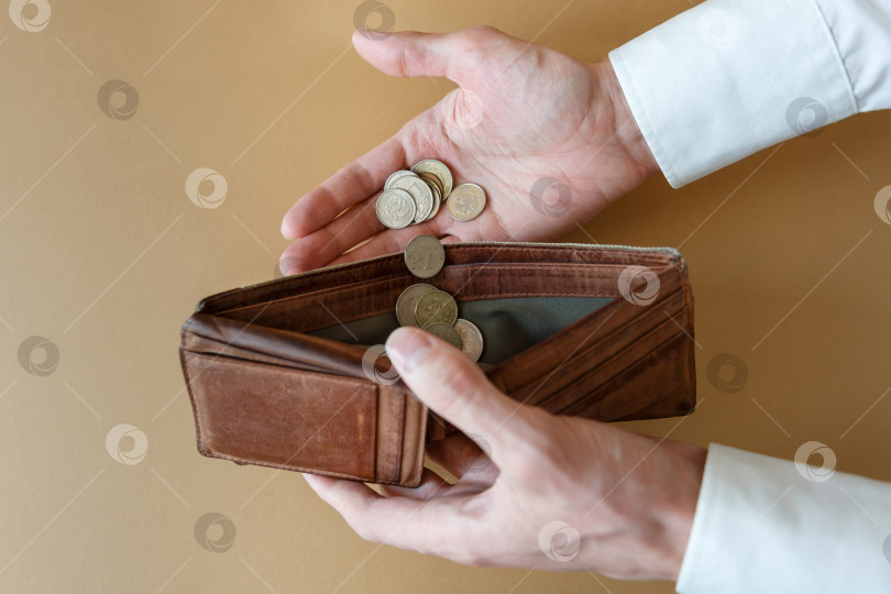 Скачать Пустой бумажник в руках мужчины на простом фоне фотосток Ozero