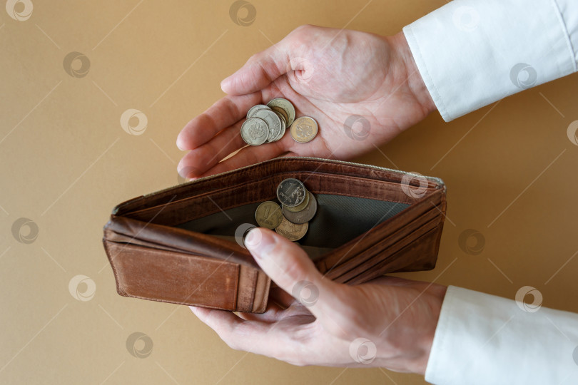 Скачать Пустой бумажник в руках мужчины на простом фоне фотосток Ozero