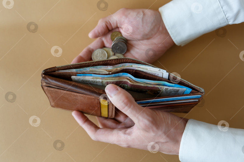 Скачать Кошелек с деньгами в руках мужчины на светлом фоне фотосток Ozero
