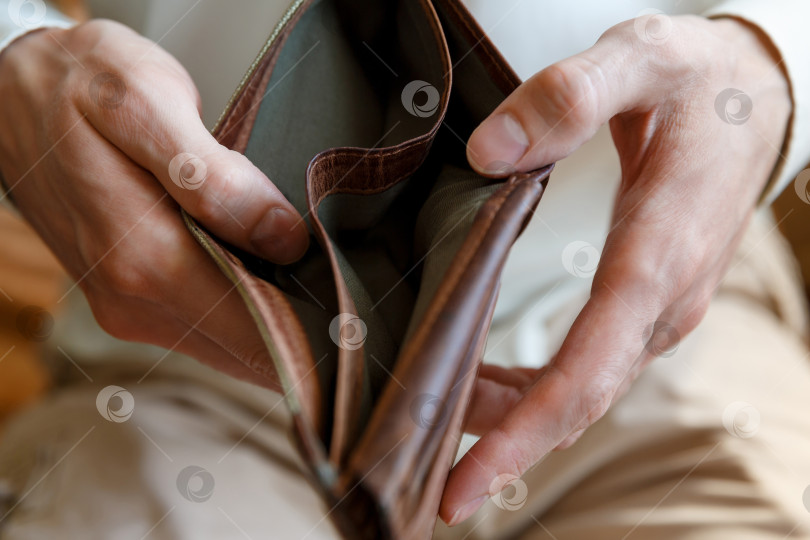 Скачать Пустой бумажник в руках мужчины на простом фоне фотосток Ozero