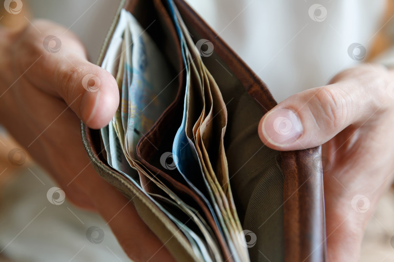 Скачать Кошелек с деньгами в руках мужчины на светлом фоне фотосток Ozero