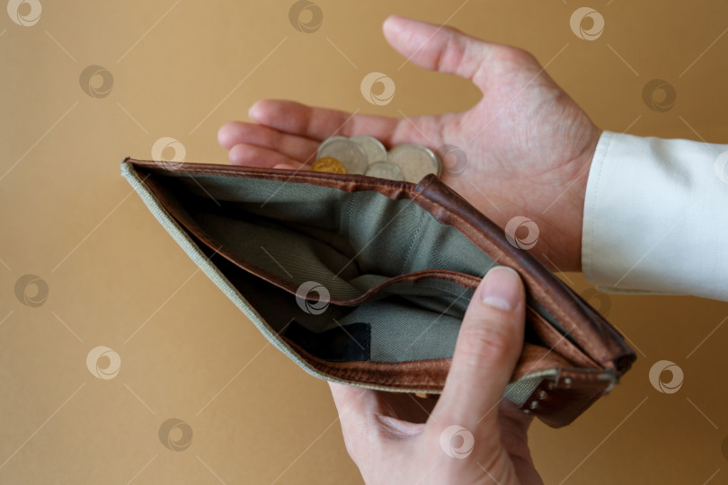 Скачать Пустой бумажник в руках мужчины на простом фоне фотосток Ozero