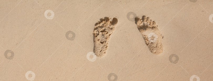 Скачать Естественная текстура и фон. Отпечатки ног на желтом песке на пляже фотосток Ozero