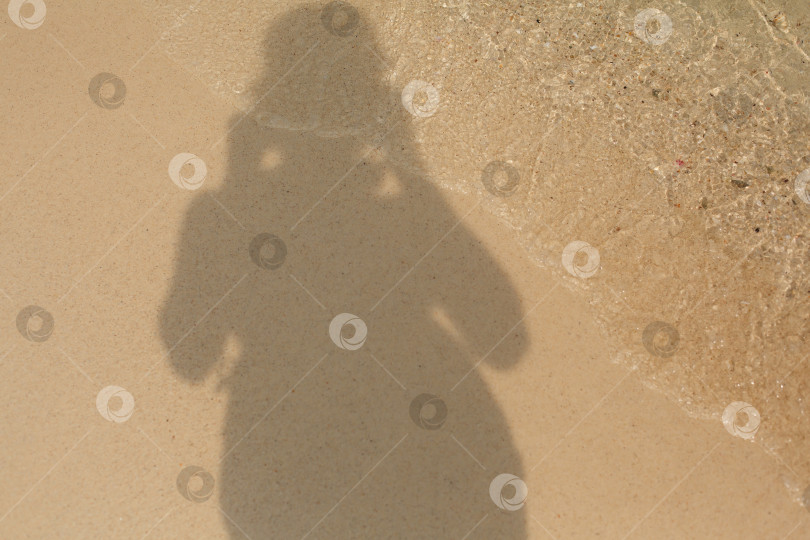 Скачать Тень человека на песчаном берегу морского пляжа в волнах воды фотосток Ozero