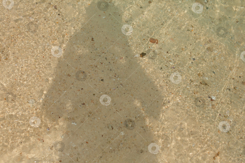 Скачать Тень человека на песчаном берегу морского пляжа в волнах воды фотосток Ozero