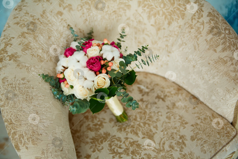 Скачать на стуле лежит свадебный букет из роз и хлопка фотосток Ozero