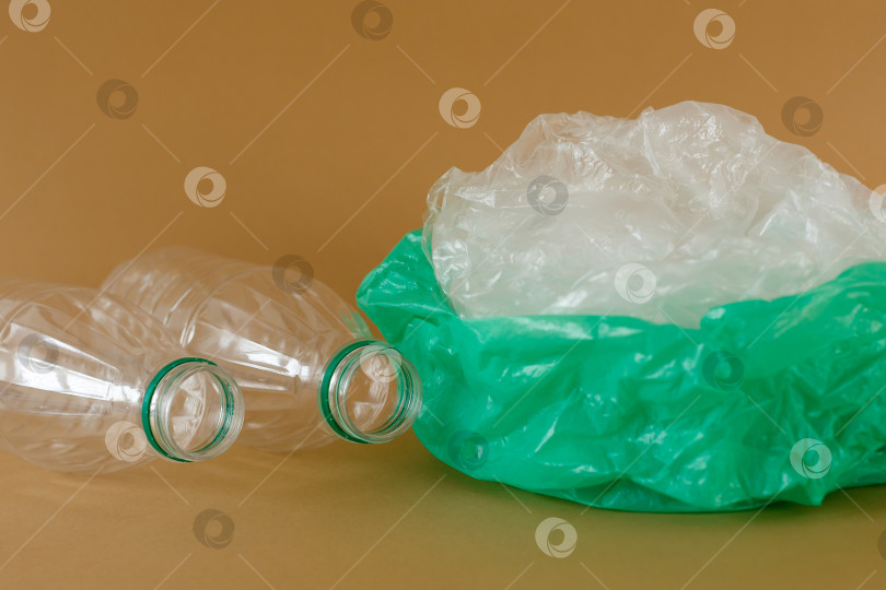 Скачать Пластиковые бутылки и полиэтиленовые пакеты на коричневом фоне фотосток Ozero