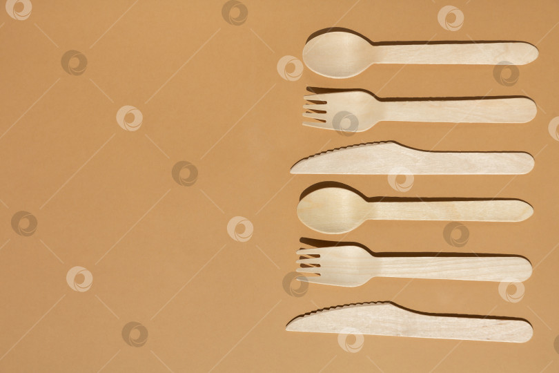 Скачать Контрастное освещение. Экологически чистые деревянные столовые приборы. Вилка, нож, ложка. Концепция без использования пластика. фотосток Ozero