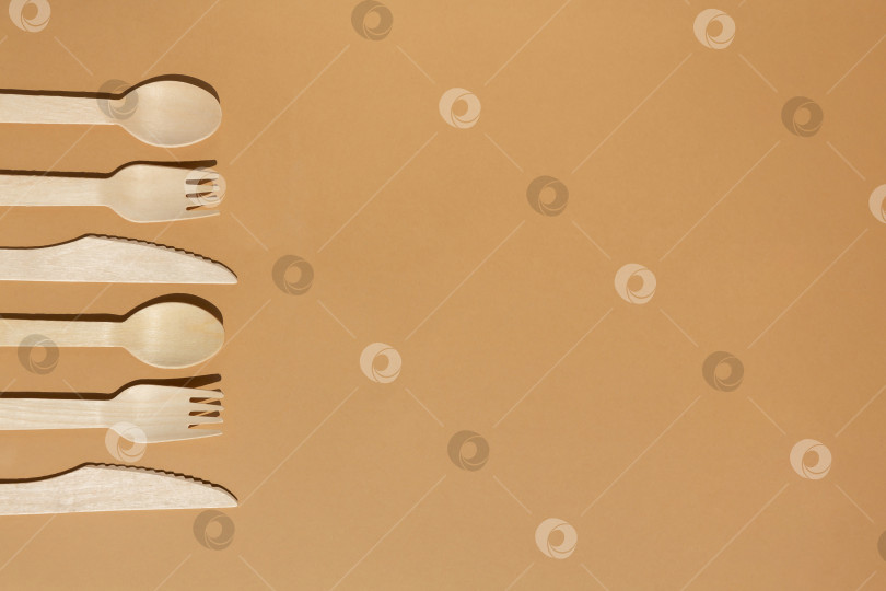 Скачать Контрастное освещение. Экологически чистые деревянные столовые приборы. Вилка, нож, ложка. Концепция без использования пластика. фотосток Ozero