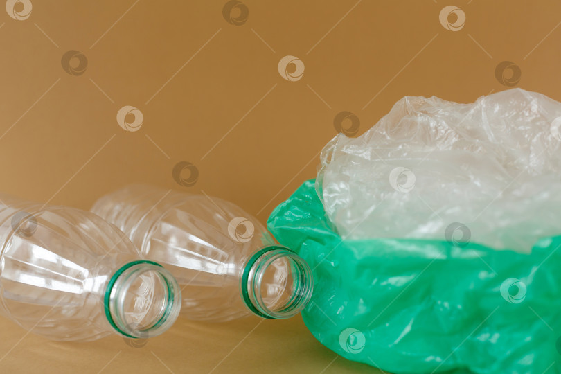 Скачать Пластиковые бутылки и полиэтиленовые пакеты на коричневом фоне фотосток Ozero