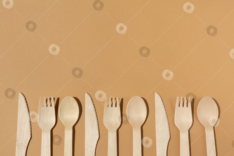 Скачать Контрастное освещение. Экологически чистые деревянные столовые приборы. Вилка, нож, ложка. Концепция без использования пластика. фотосток Ozero