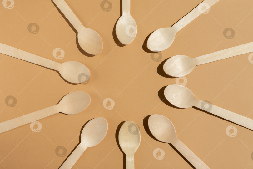Скачать деревянные ложки разложены по кругу. Контрастное освещение. Экологически чистые деревянные столовые приборы. Концепция без использования пластика. фотосток Ozero