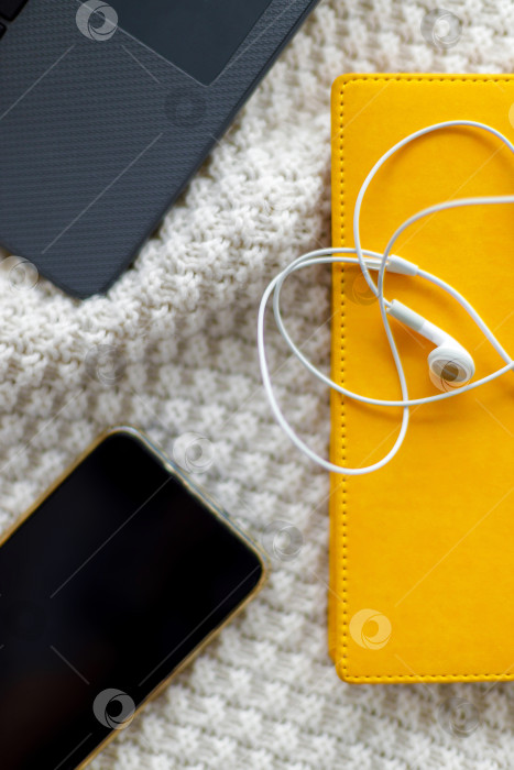 Скачать Ноутбук, блокнот и наушники лежат на вязаном пледе фотосток Ozero