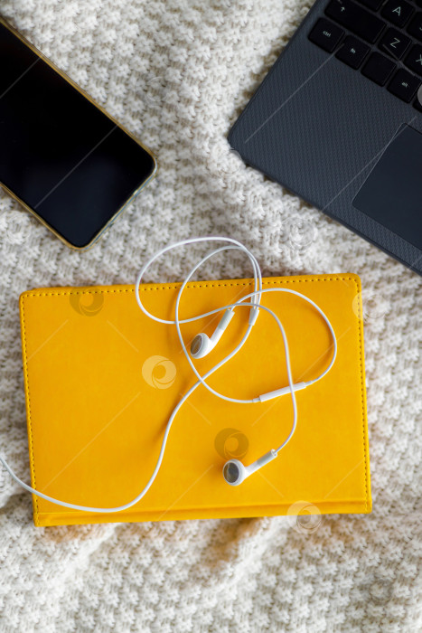 Скачать Ноутбук, блокнот и наушники лежат на вязаном пледе фотосток Ozero