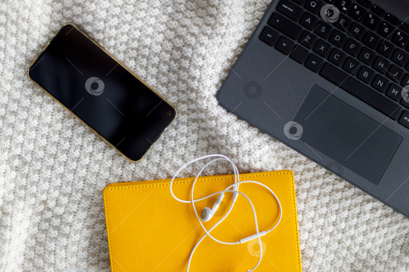 Скачать Ноутбук, блокнот и наушники лежат на вязаном пледе фотосток Ozero