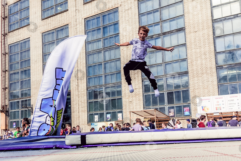 Скачать Санкт-Петербург, Россия, 6 июня 2019 года, Летом ребенок прыгает на батуте на улице фотосток Ozero