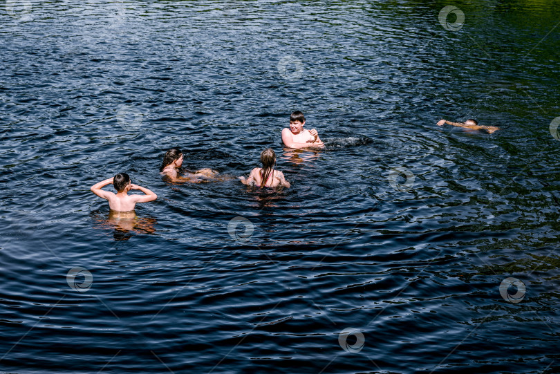 Скачать Москва, Россия, 30 мая 2020 года, компания детей-подростков купается в пруду ривер-лейк солнечным летним днем на каникулах фотосток Ozero