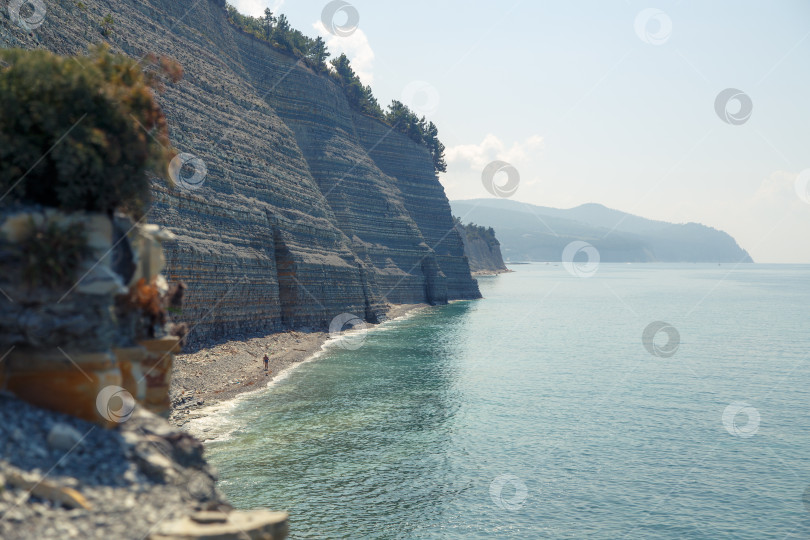 Скачать Курот Геленджик. Пляж Сосновка. Высокая белая скала и пляж у подножия обрыва. Чистое теплое море. Люди будут загорать на пляже. фотосток Ozero