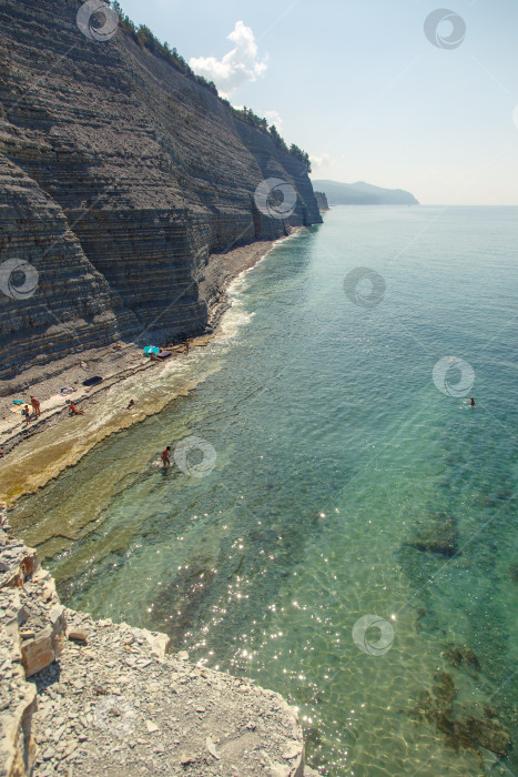 Скачать Курот Геленджик. Пляж Сосновка. Высокая белая скала и пляж у подножия обрыва. Чистое теплое море. Люди будут загорать на пляже. фотосток Ozero