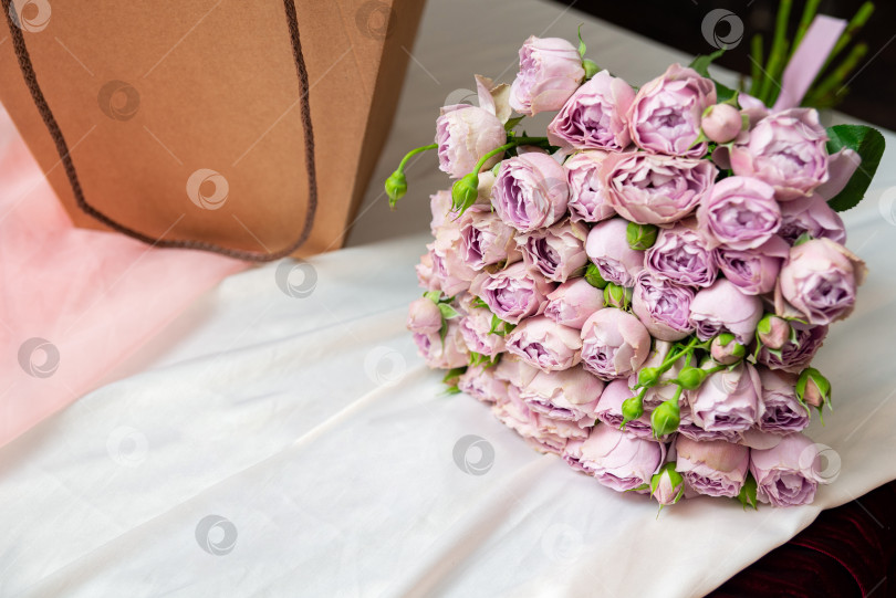 Скачать Розовые розы и подарочный пакет на белой ткани фотосток Ozero