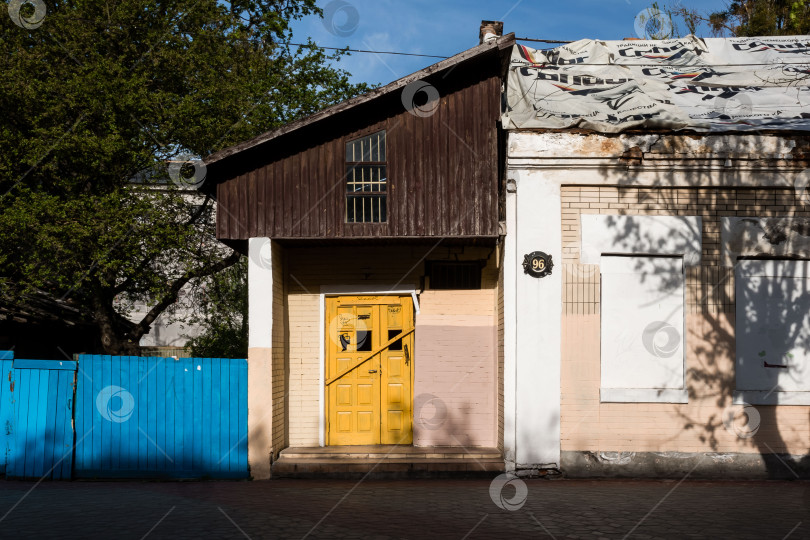 Скачать Деревенский дом с желтой дверью и синим забором в солнечном свете фотосток Ozero