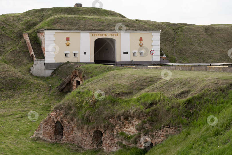 Скачать Исторический вход в крепость с зелеными холмами и руинами кирпичной кладки фотосток Ozero