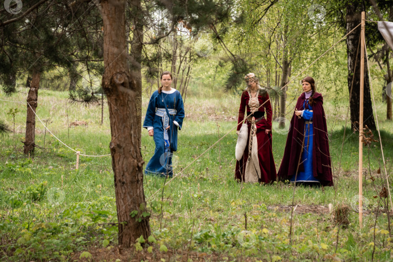 Скачать Женщины в средневековых костюмах прогуливаются по лесу фотосток Ozero