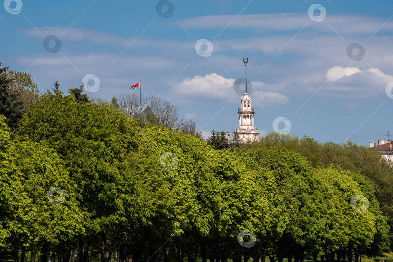 Скачать Историческая башня среди пышной зелени под голубым небом с флагом фотосток Ozero