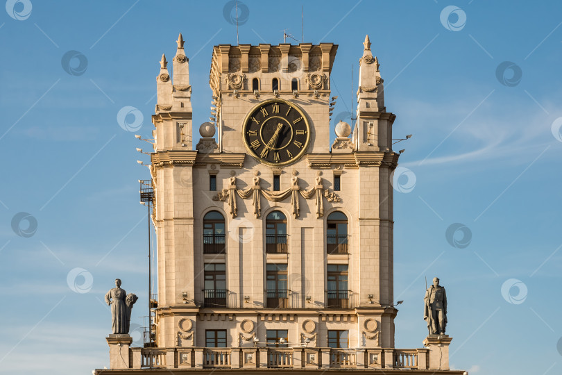 Скачать Историческая часовая башня со скульптурами на фоне ясного голубого неба фотосток Ozero