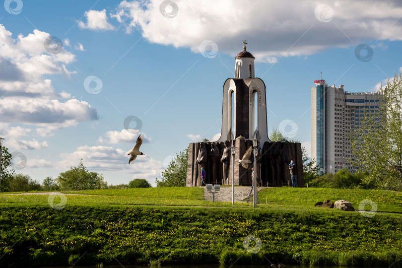 Скачать Историческая церковь с современной архитектурой в окружении пышного парка под голубым небом фотосток Ozero