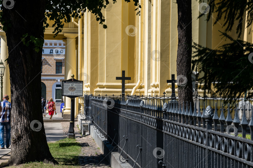 Скачать Кладбищенская дорожка мимо исторической желтой церкви с кованой оградой в городских условиях фотосток Ozero