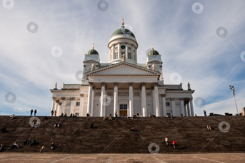 Скачать Величественный кафедральный собор Хельсинки с посетителями на лестнице под голубым небом фотосток Ozero