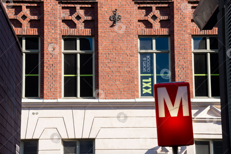 Скачать Спортивная вывеска Xxl на открытом воздухе на кирпичном здании над входом в метро фотосток Ozero