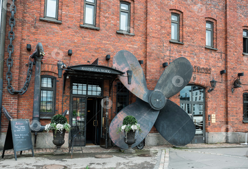 Скачать Вход в ресторан в индустриальном стиле с украшением в виде большого корабельного винта фотосток Ozero