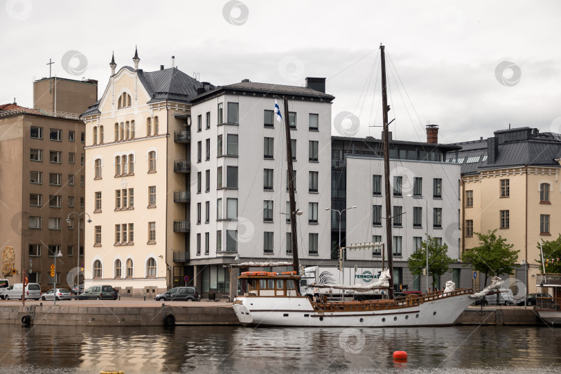 Скачать Парусник пришвартован рядом с современными и историческими зданиями в прибрежном городском пейзаже фотосток Ozero