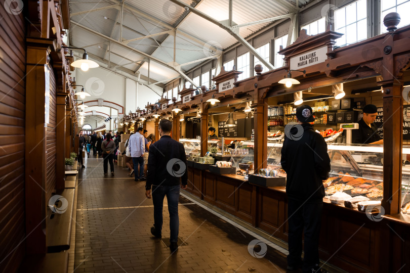Скачать Оживленный крытый рынок с покупателями и торговыми палатками под стеклянной крышей фотосток Ozero