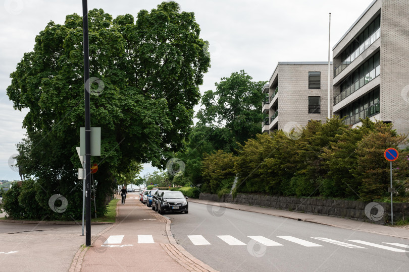 Скачать Городская уличная сцена с автомобилями и пешеходами возле современных зданий фотосток Ozero