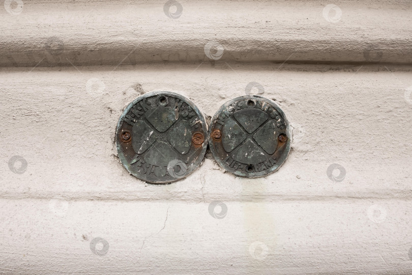 Скачать Ржавые медальоны на белой бетонной стене с индустриальной текстурой и патиной фотосток Ozero