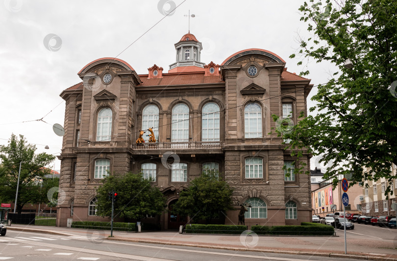 Скачать Историческое европейское здание с красной крышей и элегантной архитектурой в пасмурный день фотосток Ozero