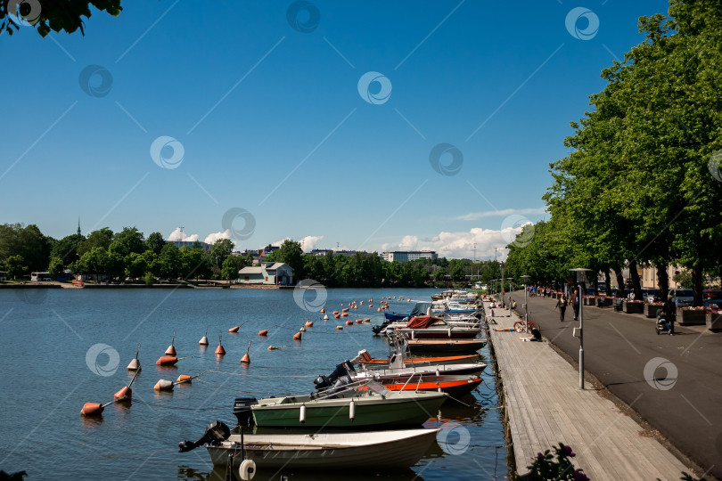 Скачать Живописный вид на лодки, пришвартованные вдоль набережной в солнечный день фотосток Ozero