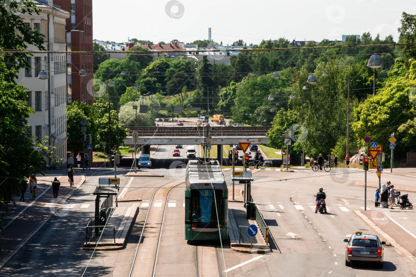 Скачать Оживленная городская улица с трамваем и уличным движением в летнем городском пейзаже фотосток Ozero
