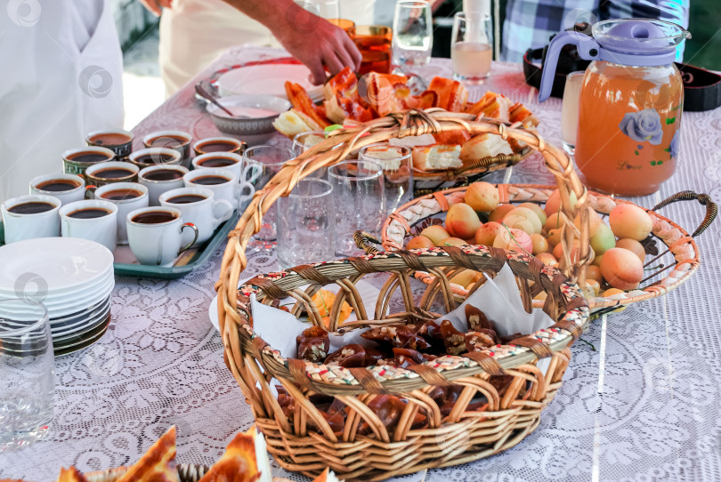 Скачать Вкусный завтрак с кофе, свежевыжатым соком и выпечкой подается на кружевной скатерти фотосток Ozero
