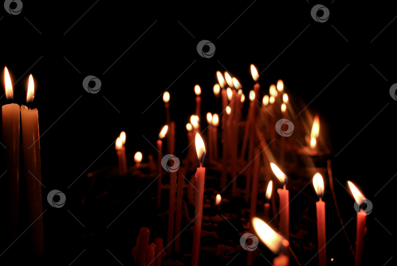 Скачать Зажженные свечи в темной обстановке создают умиротворяющее сияние фотосток Ozero