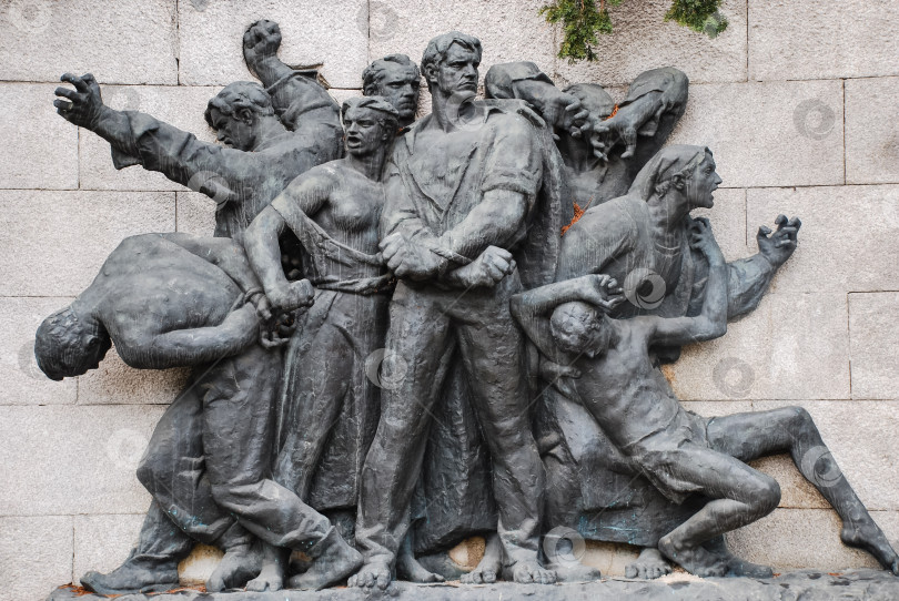 Скачать Динамичная скульптура советской эпохи, изображающая борющихся фигур на каменном фоне фотосток Ozero