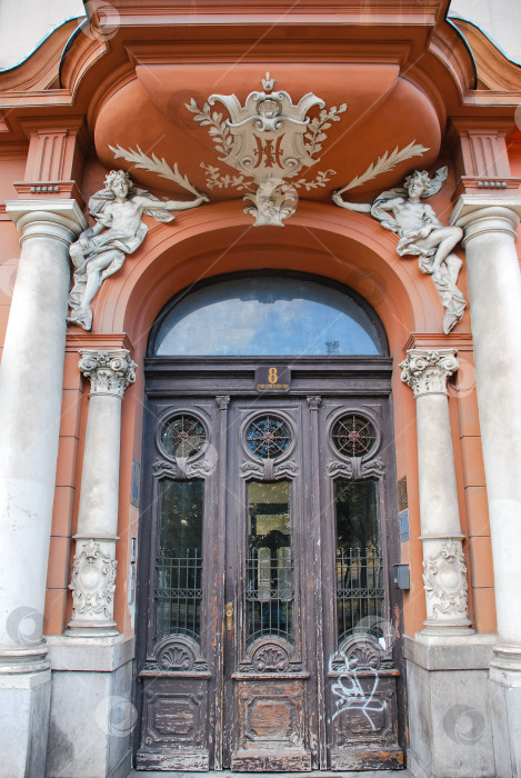 Скачать Богато украшенный исторический вход со скульптурами и декоративной аркой в городском стиле фотосток Ozero